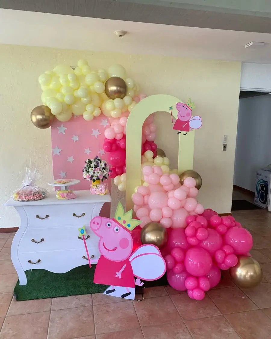 Montaje infantil en rosa, amarillo pastel y oro con arco y mesa dulce